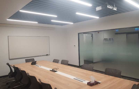 ASUS ofis fit-out uygulama örneklerinden biri olan Büyük toplantı odasında sade tavan aydınlatması, sunum ekipmanları ve cam giriş kapısıyla entegre edilmiş kurumsal toplantı ortamı