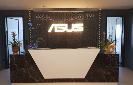 Kurumsal karşılama bölümü; aydınlatmalı ASUS yazısı, mermer görünümlü banko ve bitkilerle tasarlanmış giriş alanı
