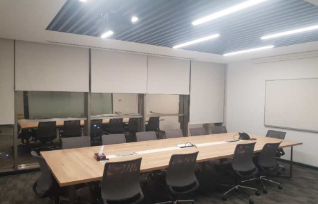ASUS ofis fit-out uygulama örneklerinden biri olan büyük toplantı odasında uzun ahşap masa, blackout perdeler ve LED tavan aydınlatmaları ile donatılmış modern iç mimari çözüm