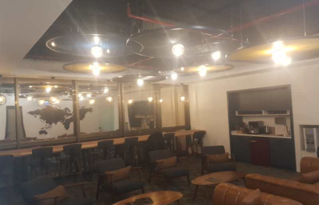 ASUS ofis fit-out uygulama örneği olarak modern ofis sosyal alanı; mini mutfak bölümü, yüksek bar sandalyeleri, dekoratif aydınlatmalar ve deri koltuk oturma alanı