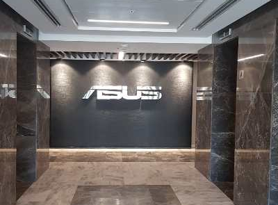 ASUS Türkiye ofisi iç mimari uygulama projesinde marka imajını vurgulayan ofis giriş tasarımı; loş aydınlatmalı koyu duvar ve zemin kaplaması ile karşılamada prestij